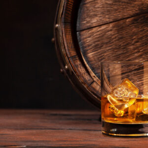 Bourbon glass and an old wooden barrel.