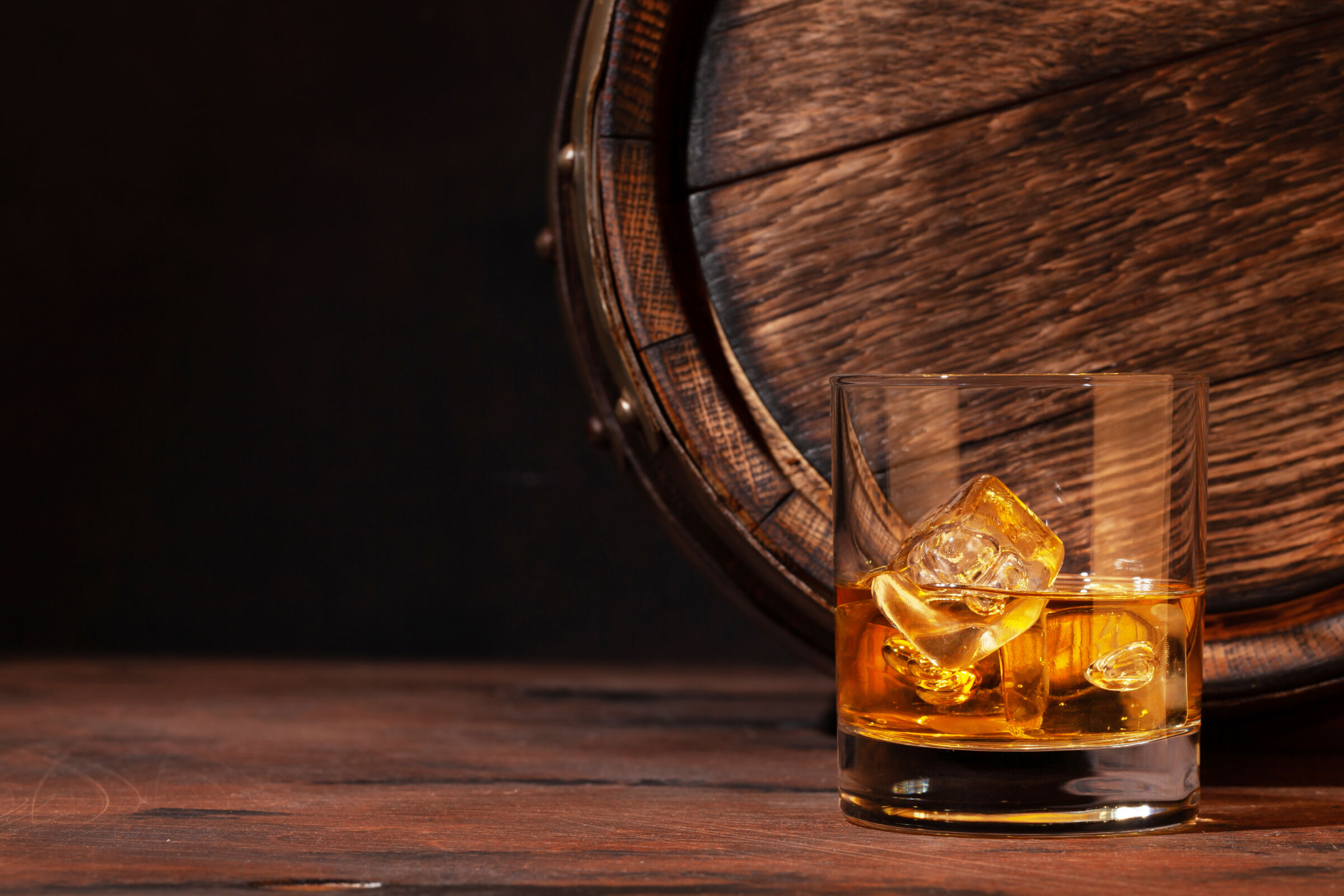 Bourbon glass and an old wooden barrel.