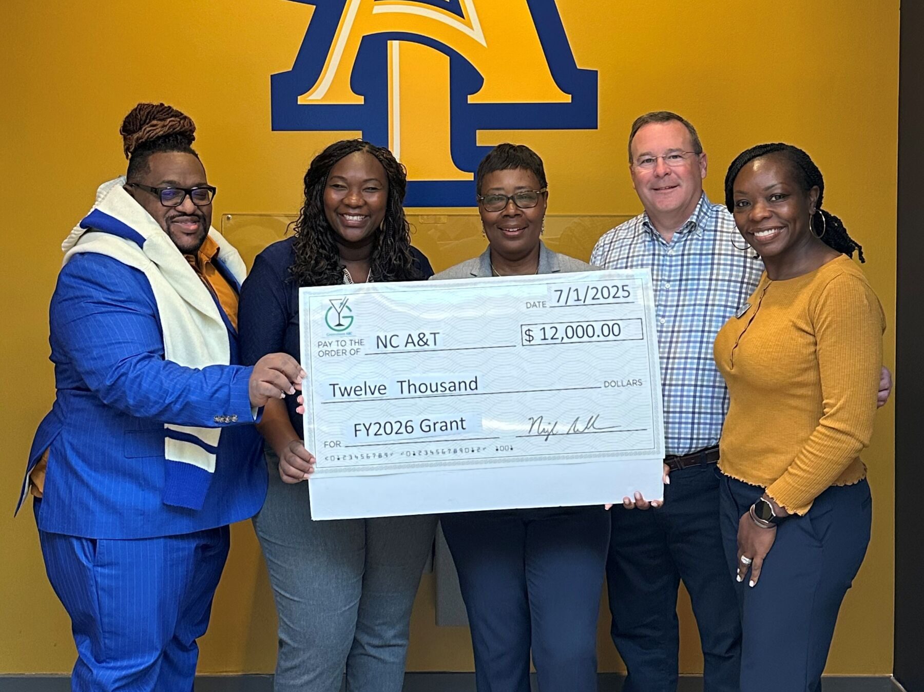 NC A&T accepting a grant check from Greensboro ABC for $12,000.