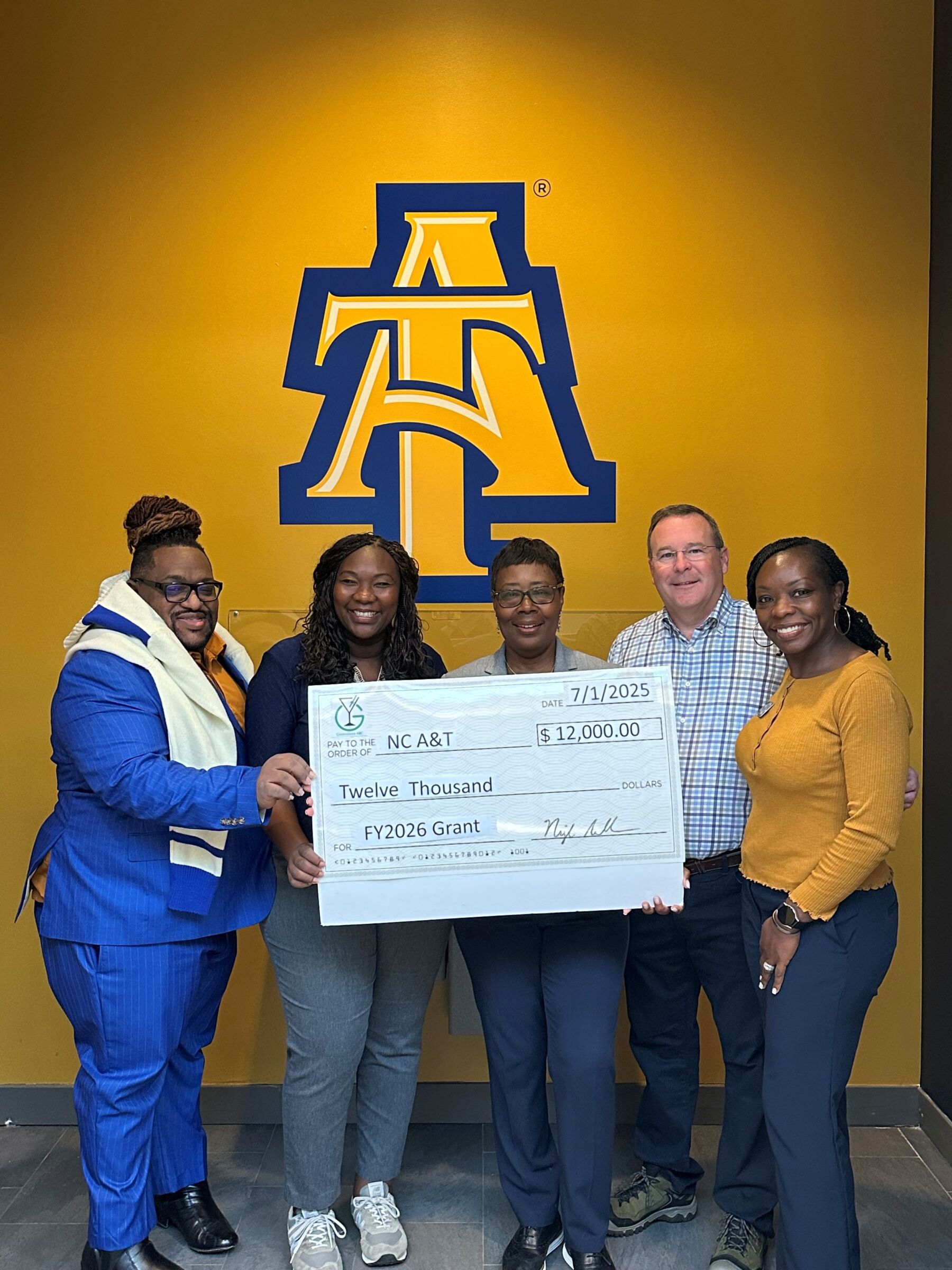 NC A&T accepting a grant check from Greensboro ABC for $12,000.
