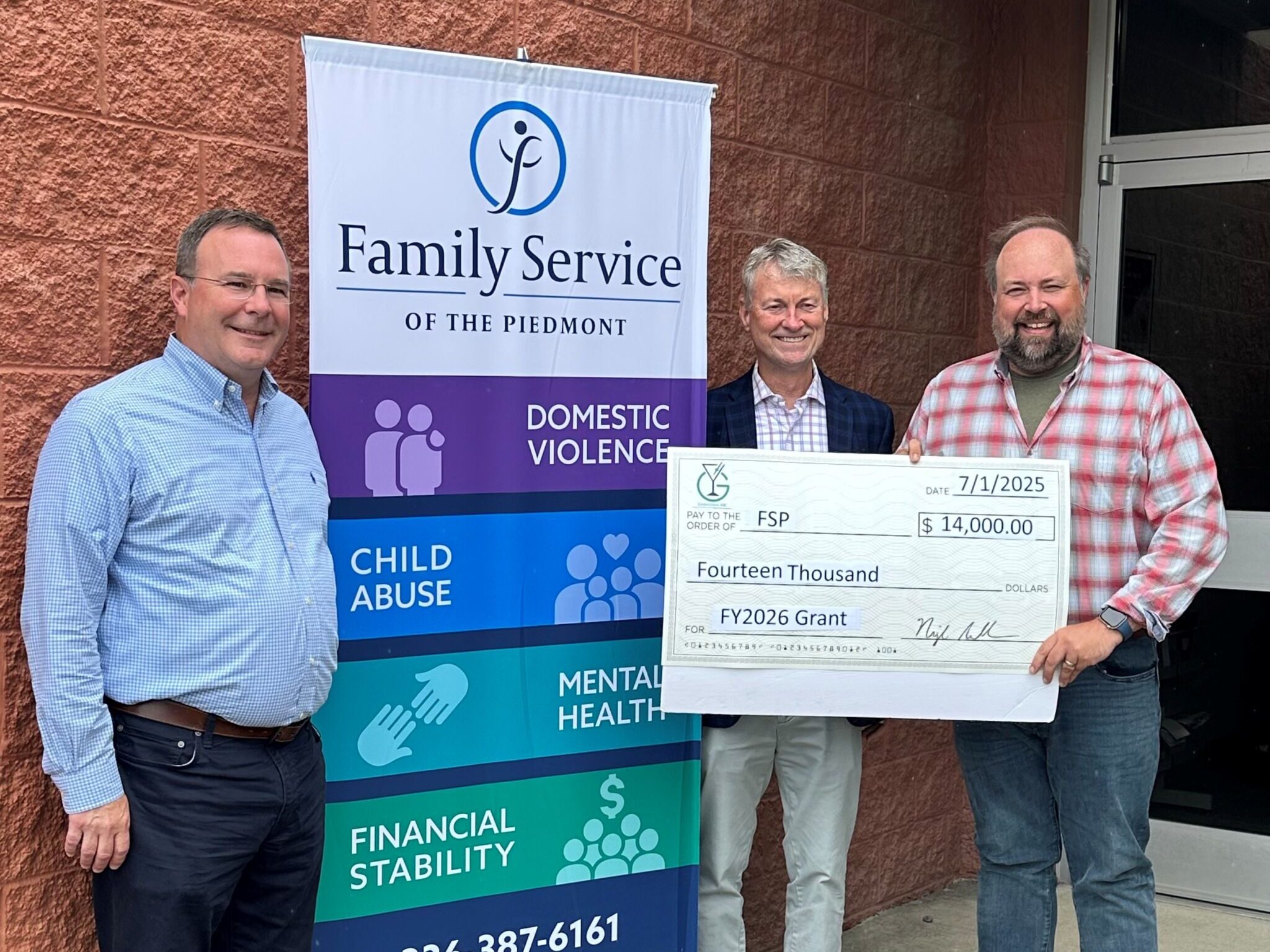 Family Service of the Piedmont accepting a grant check from Greensboro ABC for $14,000.