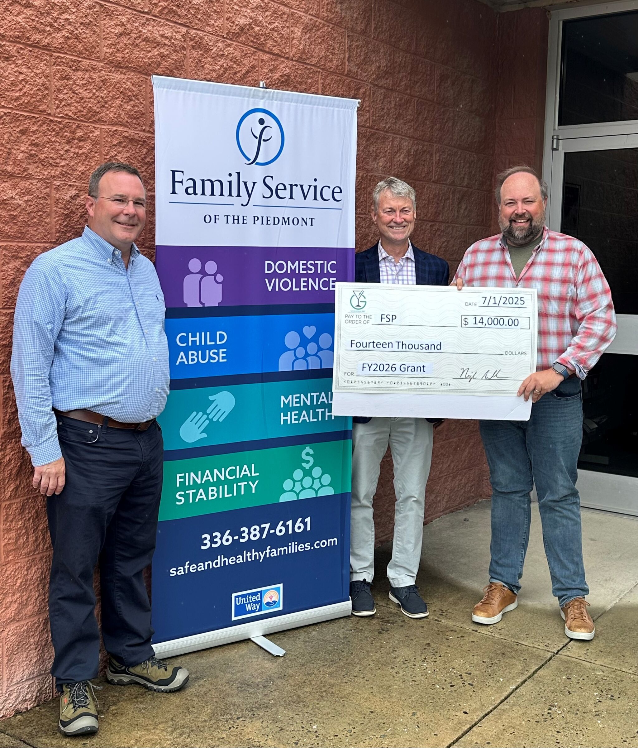 Family Service of the Piedmont accepting a grant check from Greensboro ABC for $14,000.