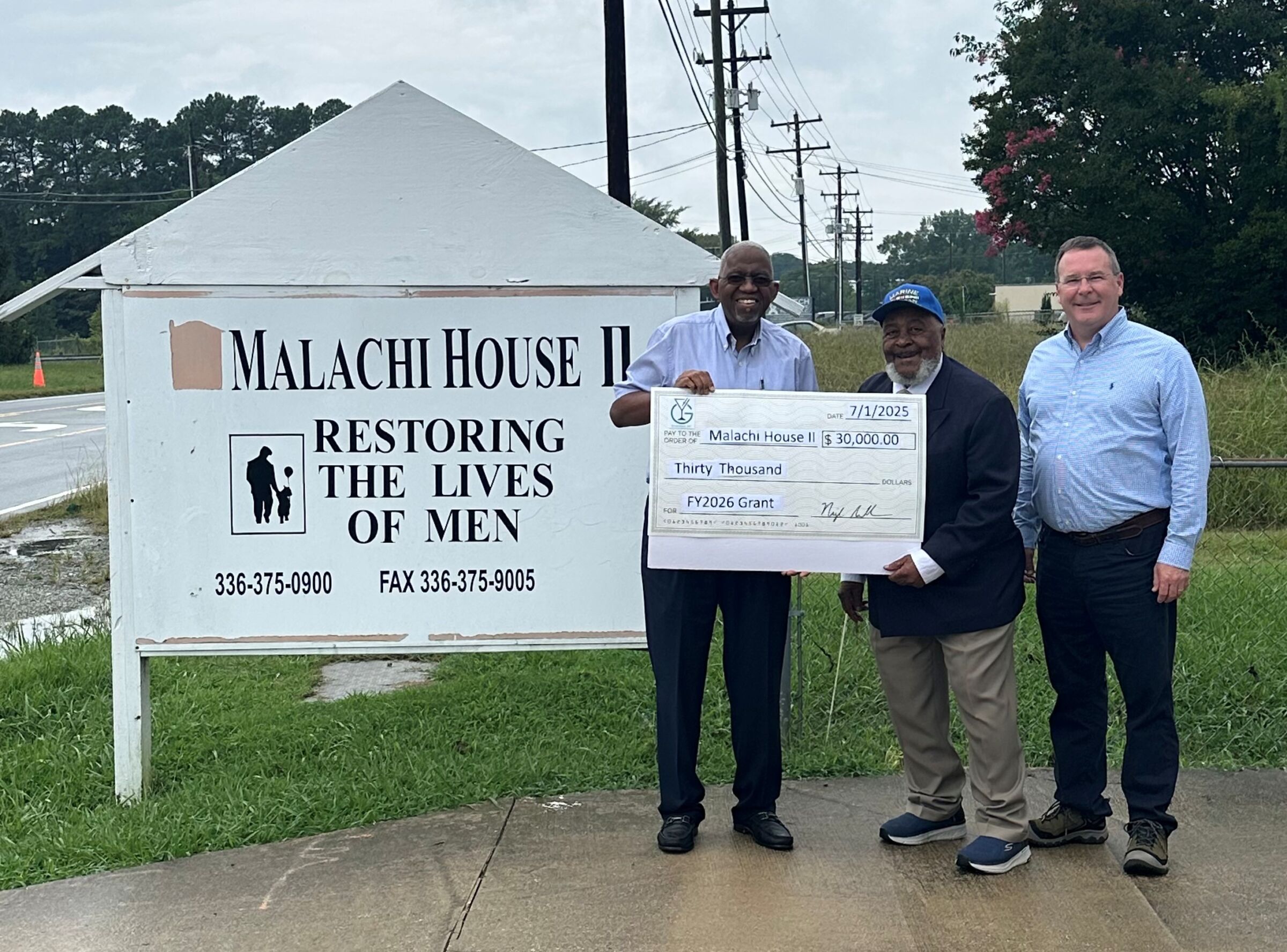 Malachi House II accepting a grant check from Greensboro ABC for $30,000.