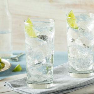 Glass with a vodka drink containing lime and ice